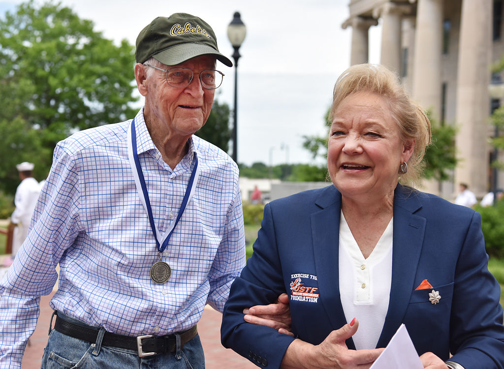 World War II veteran Bill Crabb, left, walks with Susan Haines